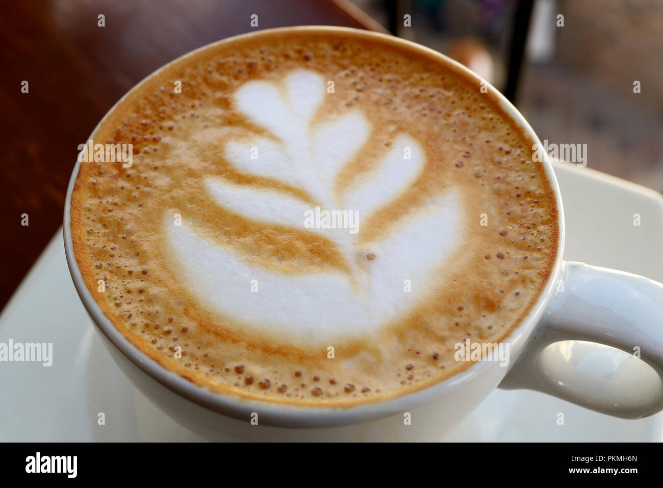 Chiuso fino a caldo il caffè cappuccino con Latte Art in una tazza bianca Foto Stock