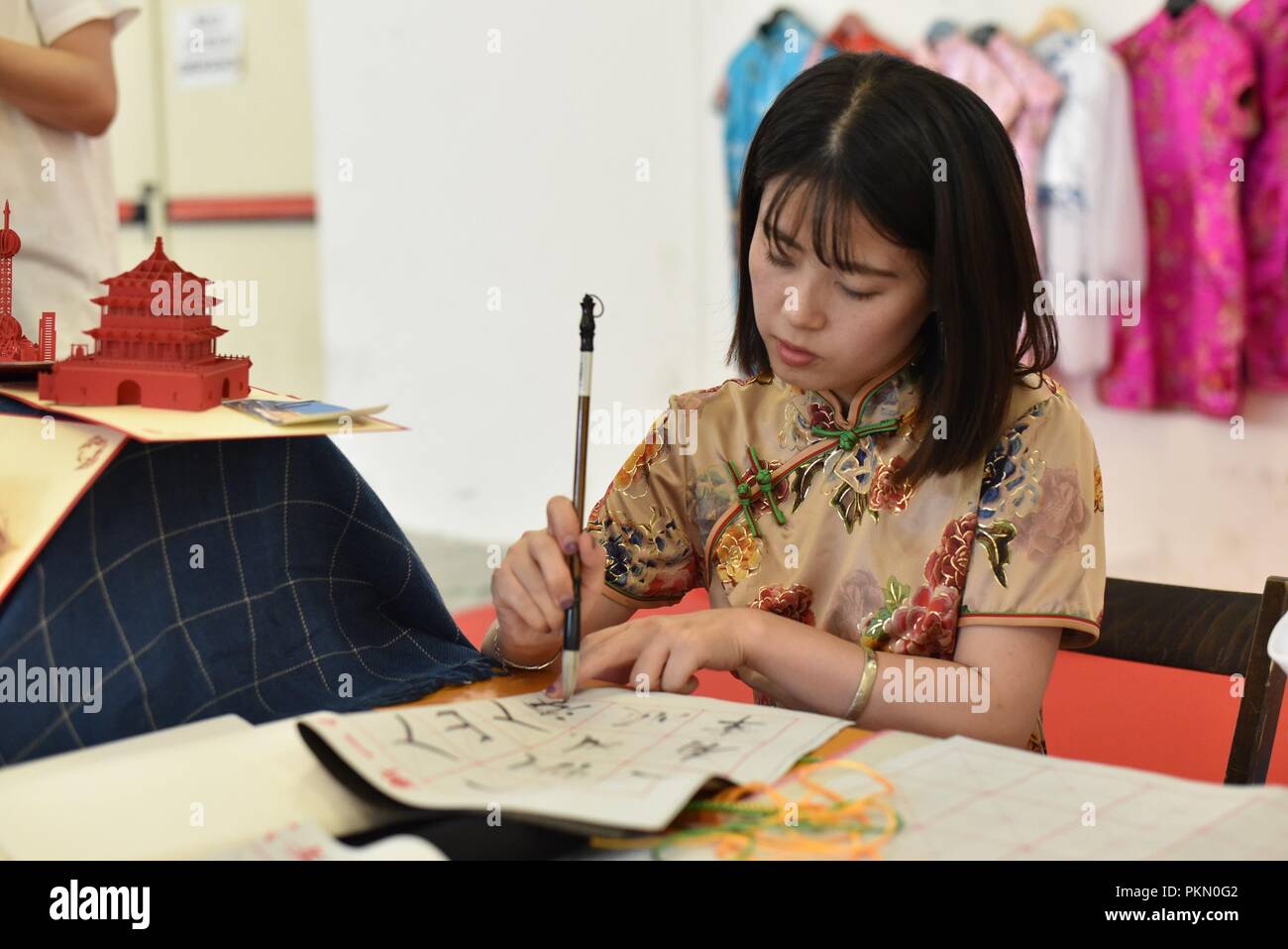 Napoli, Italia. Xiv Sep, 2018. Una donna si vede vestito di usura tradizionale la scrittura di lettere tradizionali durante il festival.Il Festival dell' Oriente torna a Napoli per tre giorni, presso il complesso espositivo di ''Mostra d'oltremare''. Immersione totale nella cultura orientale e le tradizioni di un immenso continente con la gastronomia tipica, le cerimonie tradizionali, folklorisitici mostra, le medicine naturali, concerti, danze e arti marziali si trasforma in molte zone a tema dedicati a diversi paesi in un continuo e avvincente serie di spettacoli, incontri, seminari e mostre. (Cred Foto Stock