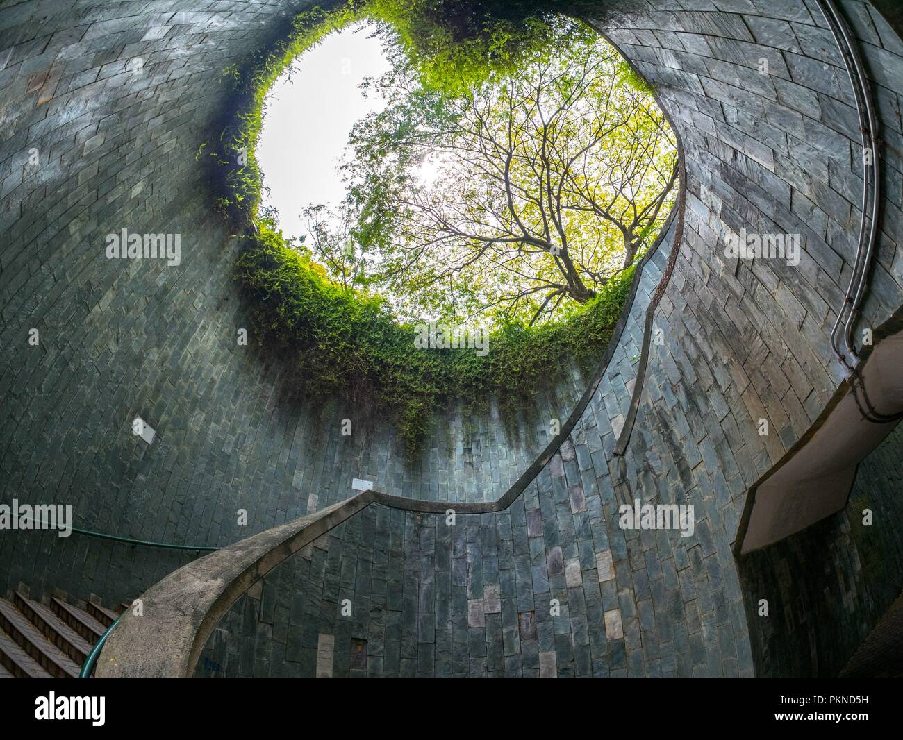 La scala a chiocciola di attraversamento sotterraneo nel tunnel a Fort Canning Park, Singapore Foto Stock