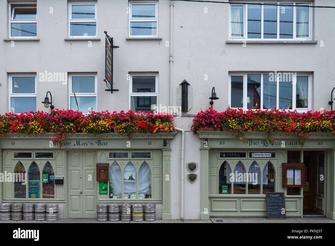 Annie Mays Bar skibbereen West Cork in Irlanda con la fioritura estiva nei cestini appesi sopra le finestre. Foto Stock