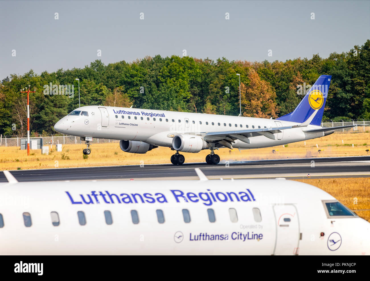 Un Embraer 190 (D-AECI;) della Lufthansa CityLine sbarco sulla Nordwestbahn all'aeroporto di Francoforte. In primo piano un Bombardier CRJ-900 (D-ACNP) di Foto Stock