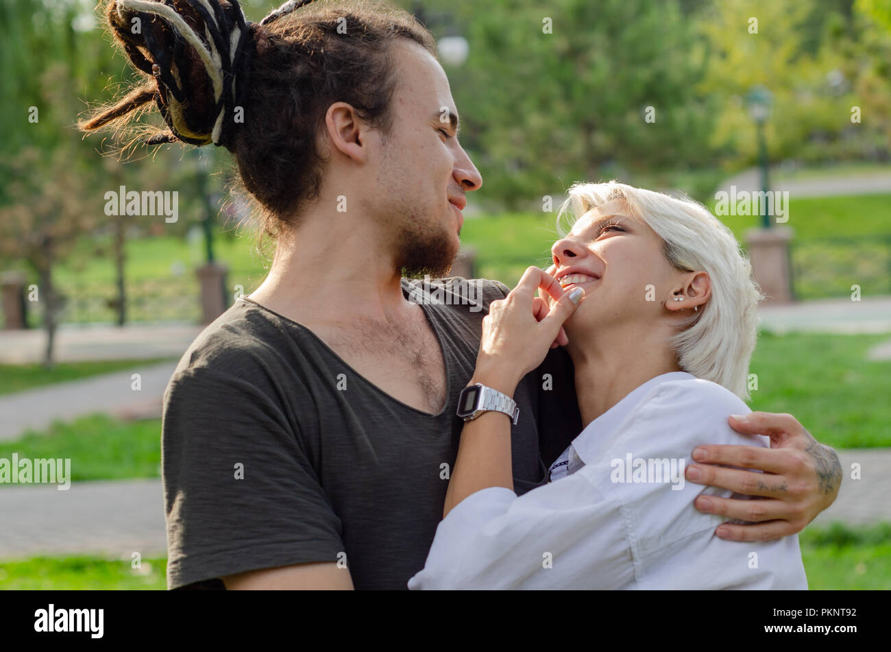 Bella amare giovane è di trascorrere del tempo insieme al parco.il giovane uomo ha preso il suo amore nelle sue braccia. Foto Stock