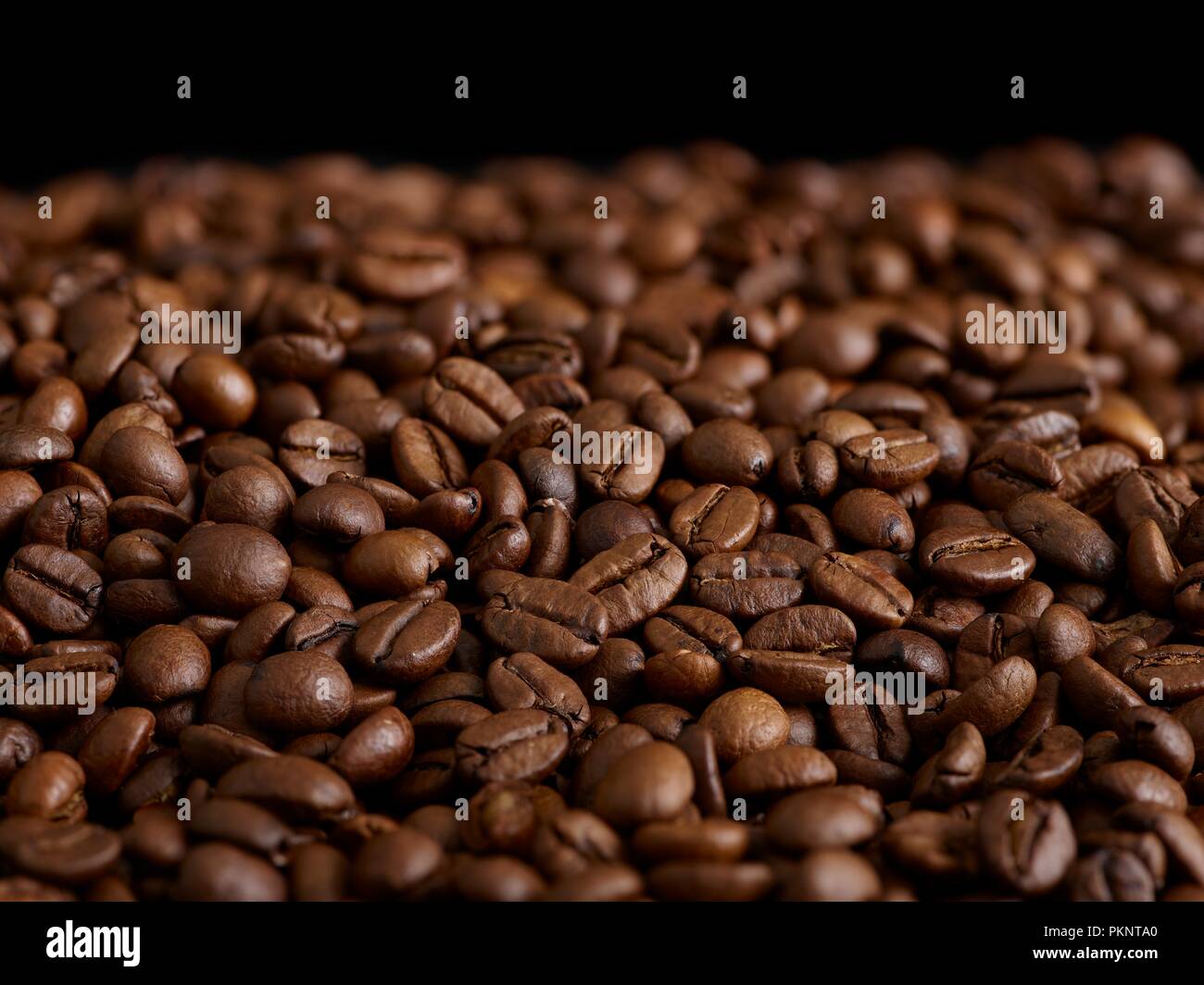 I chicchi di caffè contro uno sfondo nero. Foto Stock