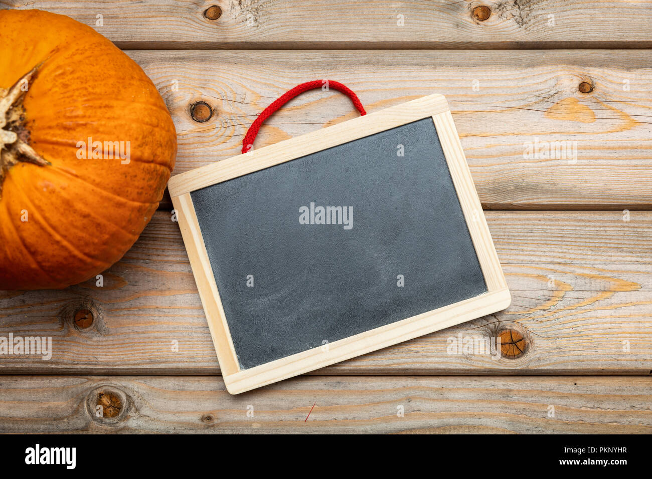 Halloween, Ringraziamento. La zucca e lavagna vuota su legno backgroound, copia spazio, vista dall'alto Foto Stock