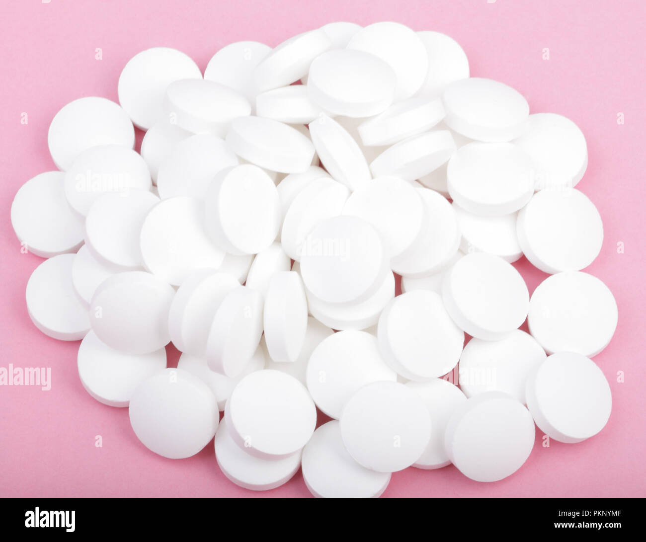 Pillola bianco su sfondo rosa al giorno Foto Stock