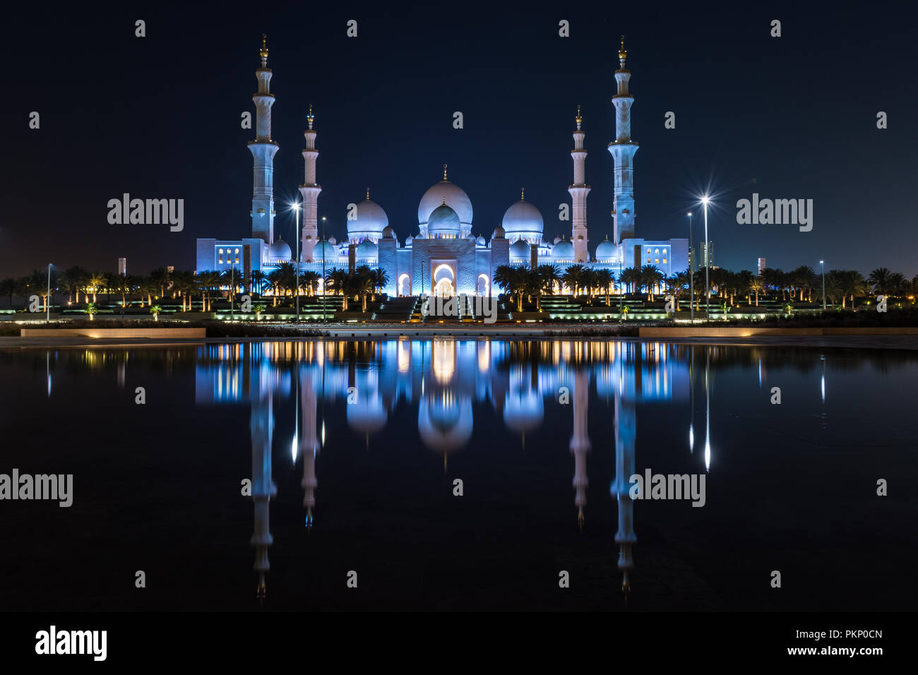 Abu Dhabi negli Emirati Arabi Uniti vanta una spettacolare icona islamica nella Grande Moschea. Una vista notturna di luci e di stagno riflettente - wow! Foto Stock