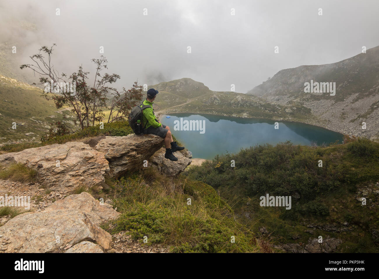 Un uomo escursionista escursioni di montagna con uno zaino sentieri di uno stile di vita all'aperto uno scenario paesaggistico backpacking zaino Foto Stock