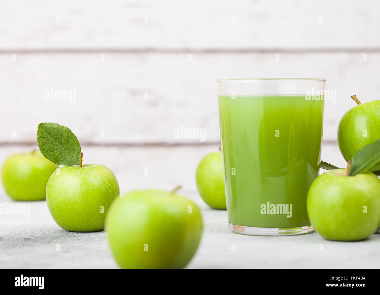 Bicchiere di fresco succo di mela biologico con la Granny Smith e british bramley mele nella casella su sfondo di legno. Foto Stock