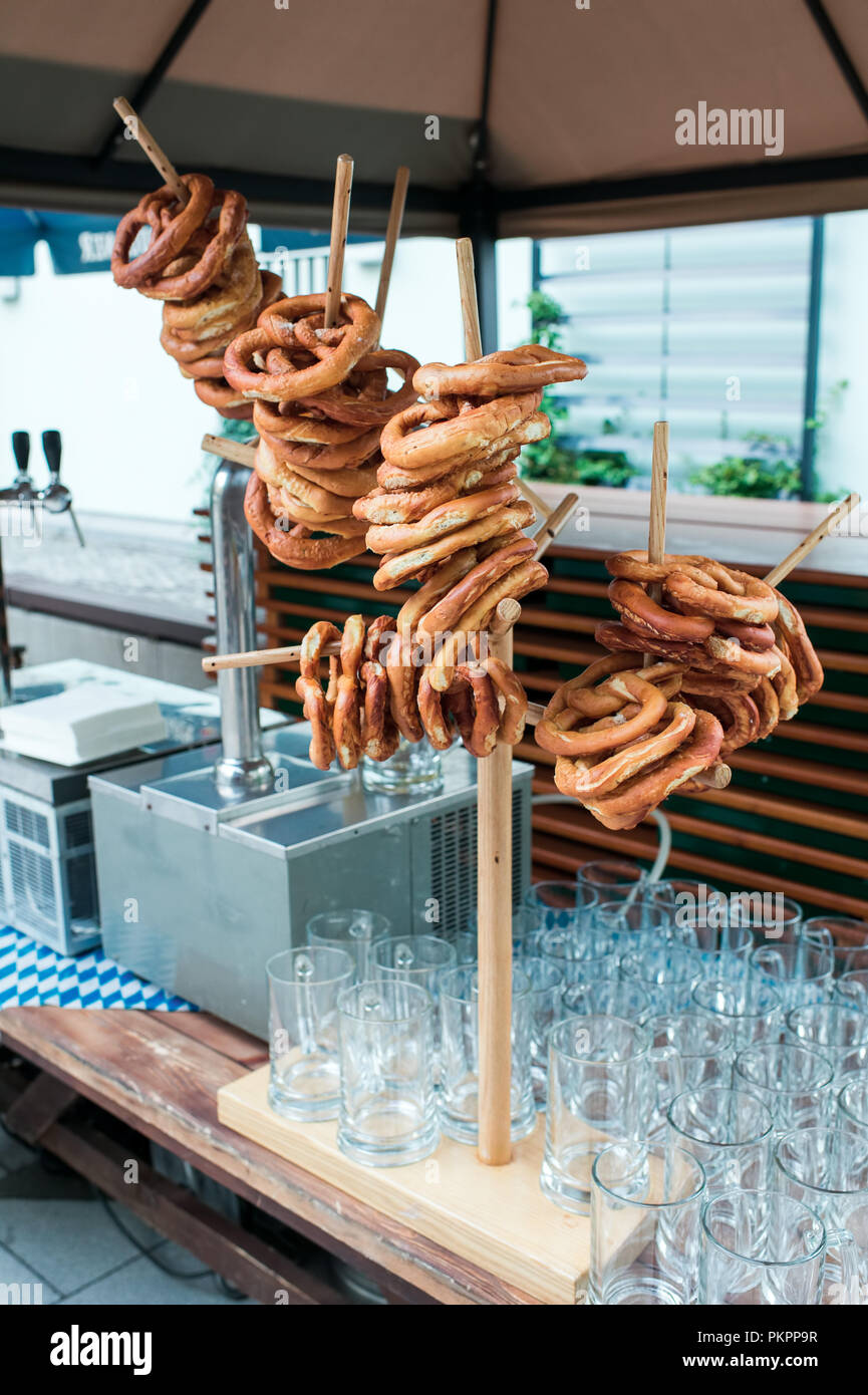 Fresca pretzel tedesco su un rack di legno per la birra Foto Stock