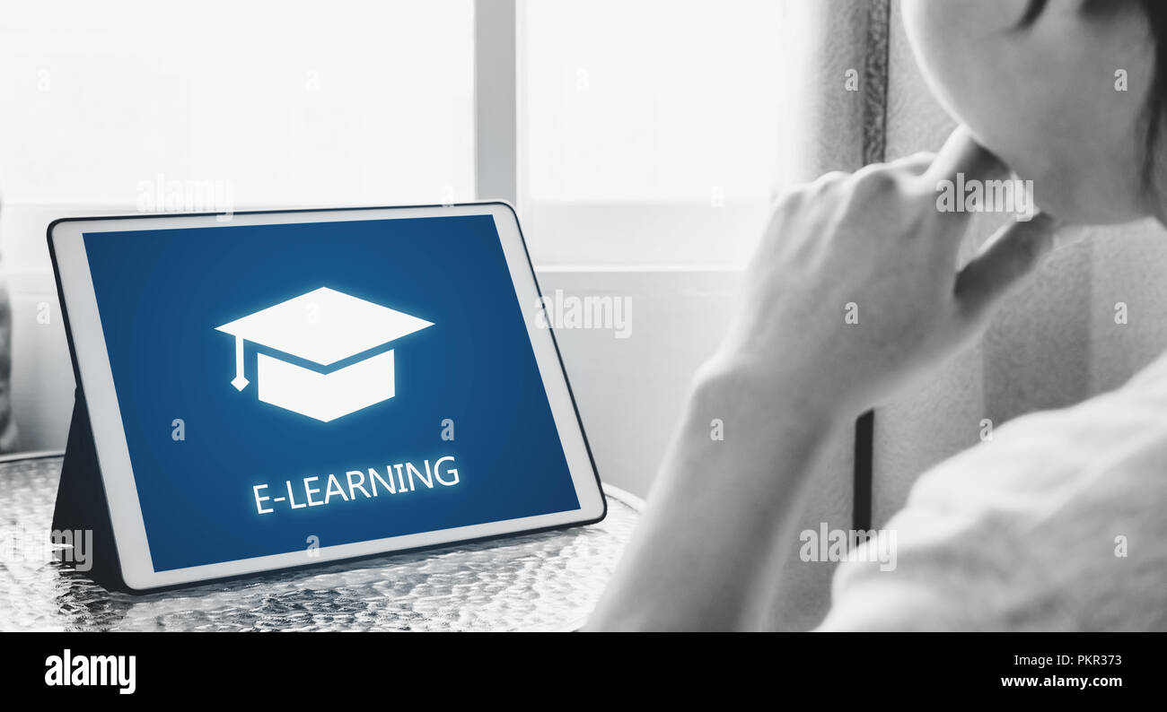 Formazione online, e-learning e e-book concetto. Un uomo con tavoletta digitale per l'istruzione a casa Foto Stock