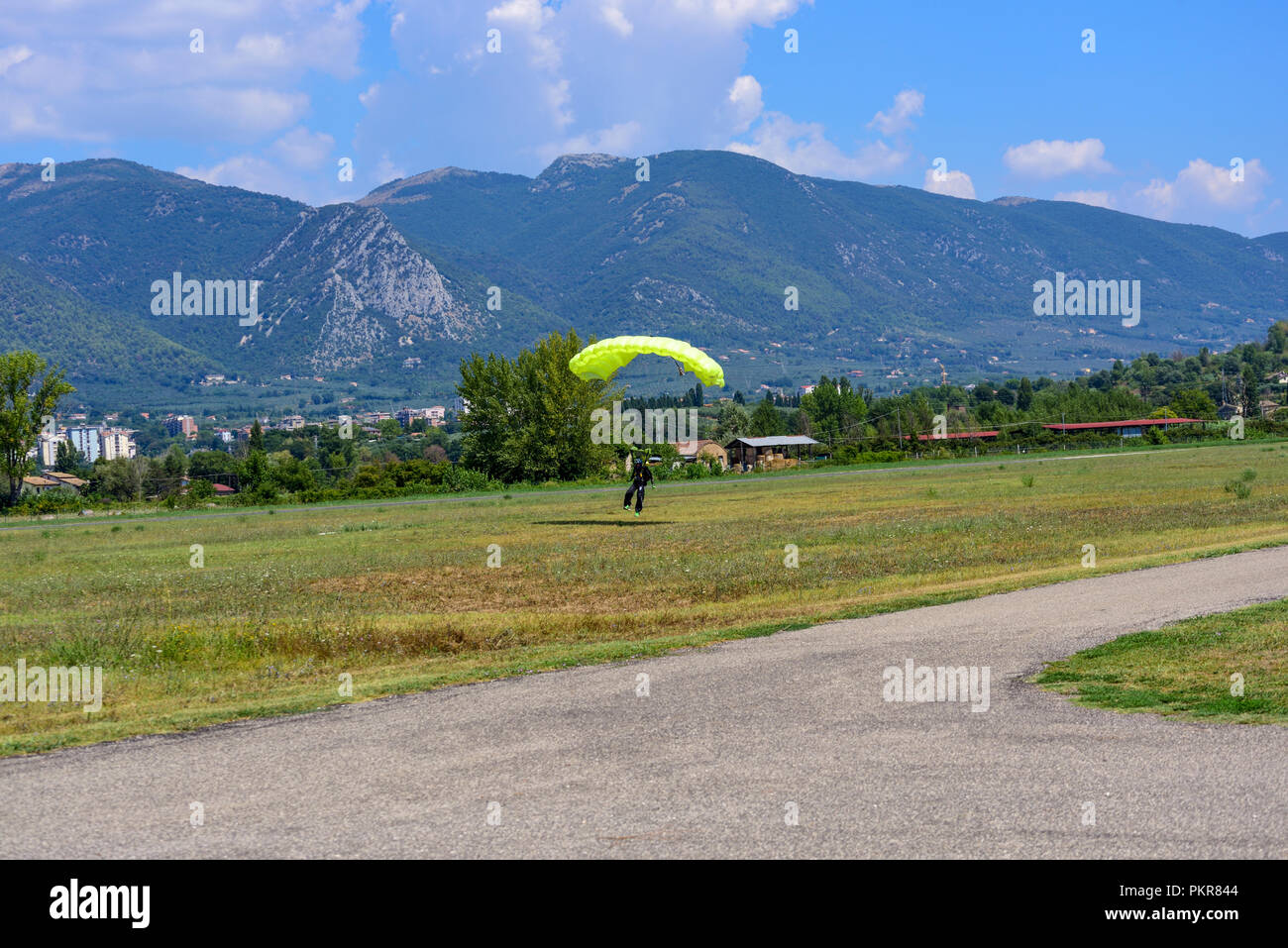 Parachutist con paracadute gialli atterra sul campo di volo Foto Stock