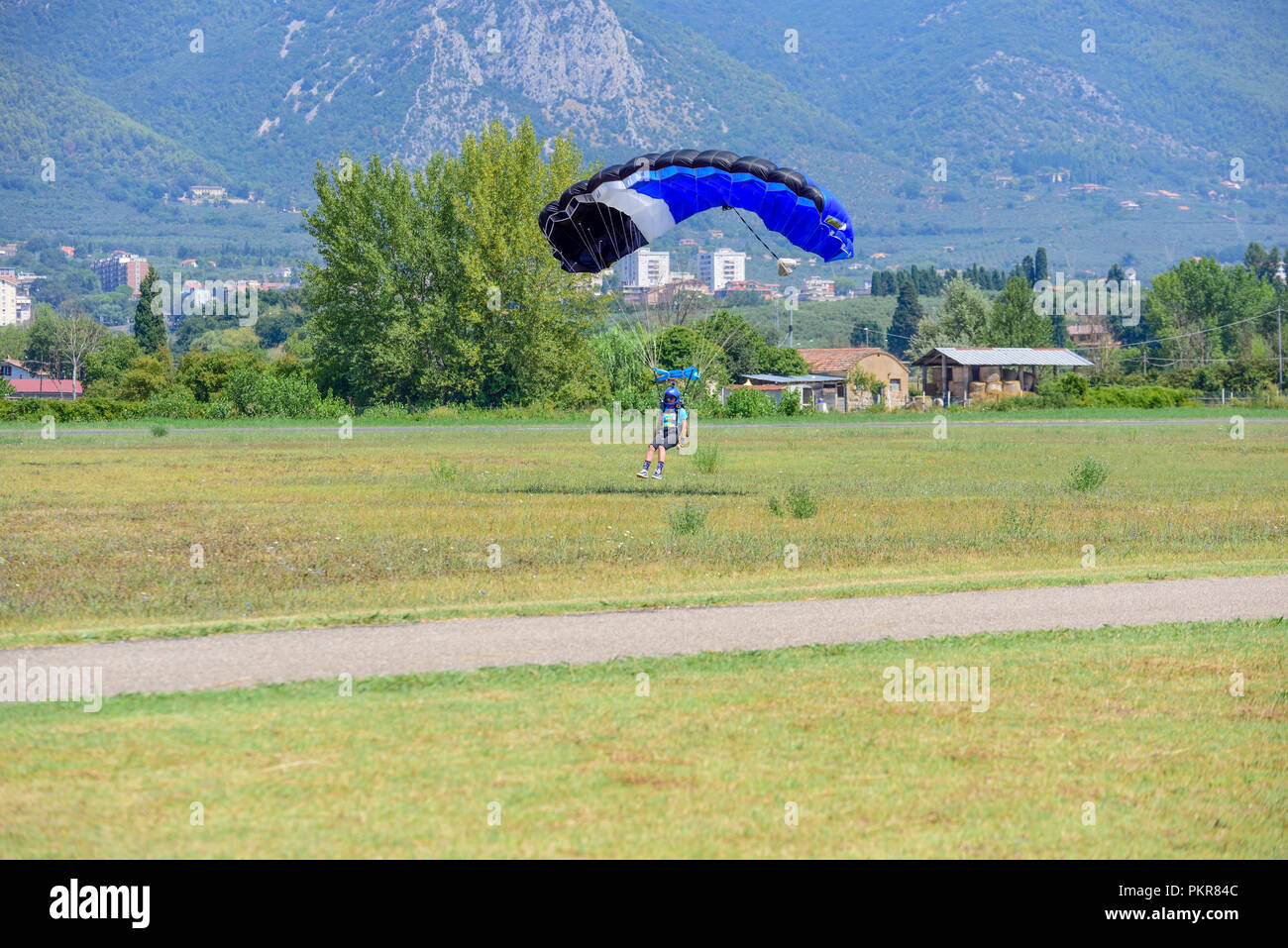 Parachutist con paracadute gialli atterra sul campo di volo Foto Stock