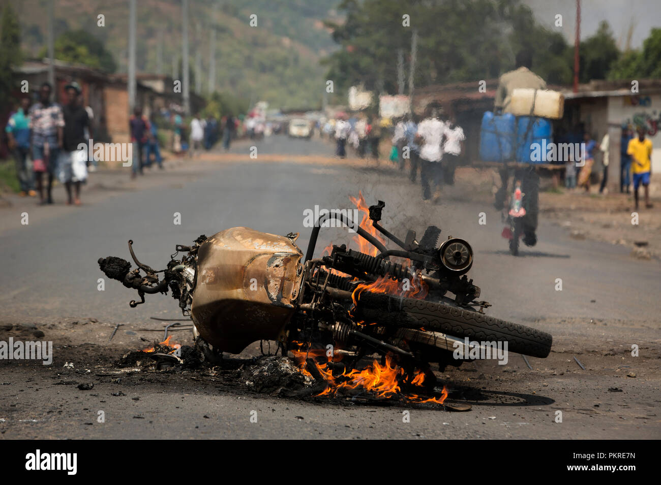 Una moto incendiati dai manifestanti ustioni su una strada nella capitale Bujumbura, Burundi, 3 giugno 2015. Foto Stock