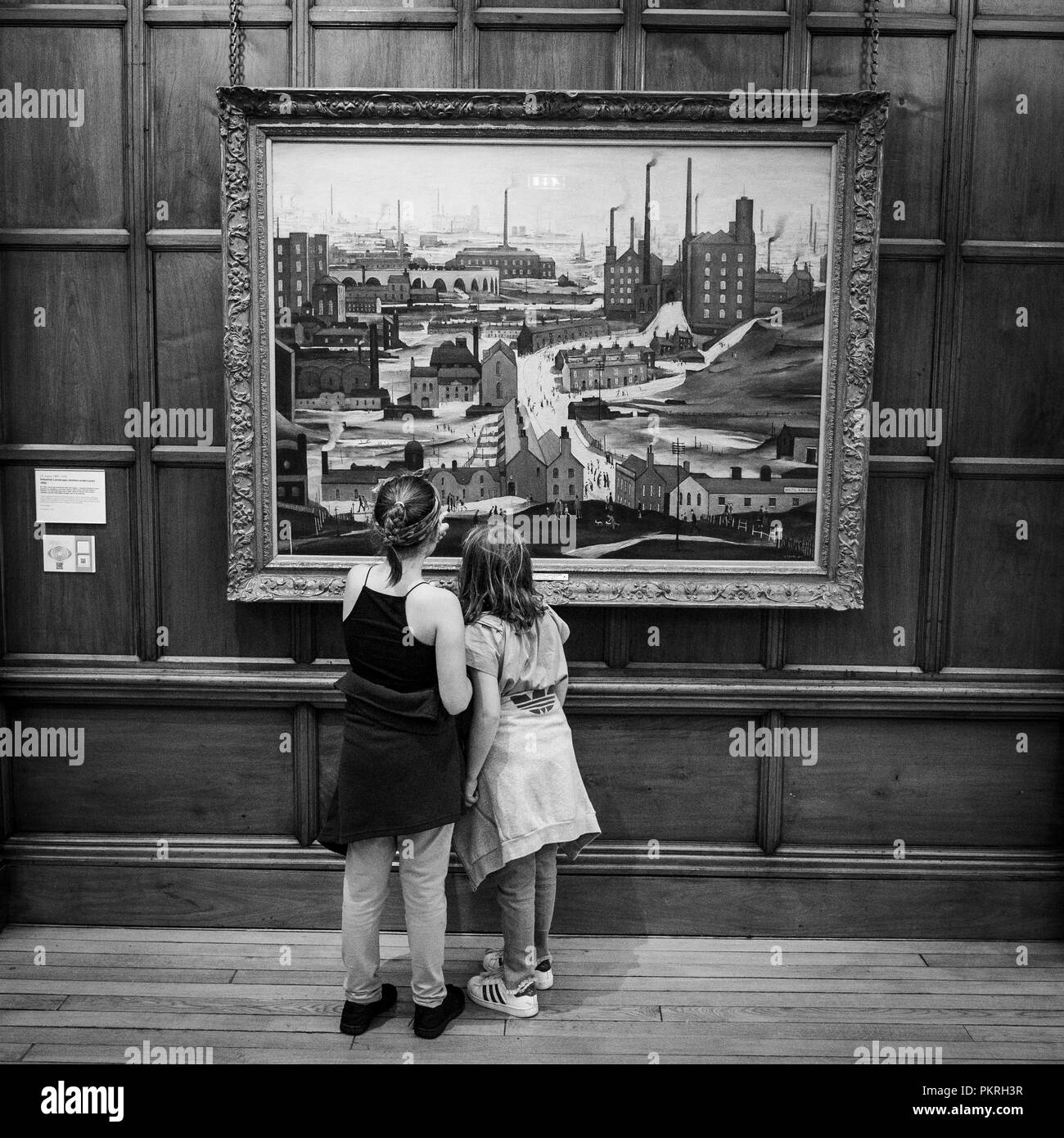Due ragazze ammirando una pittura di Lowry, all'interno di Cartwright Hall Art Gallery, Lister Park, Bradford, West Yorkshire, Regno Unito Foto Stock