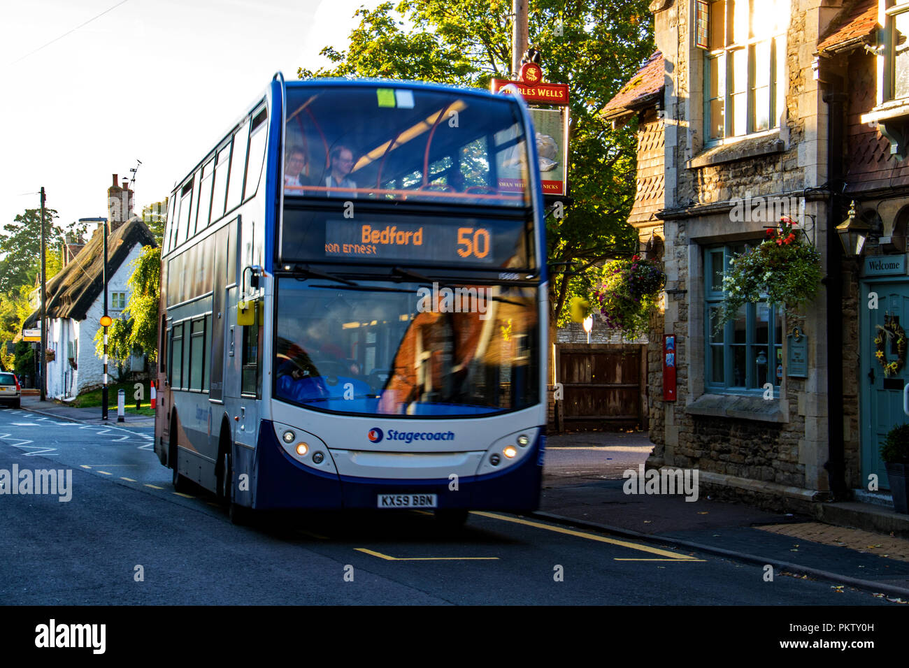 Un autobus che passa in un paese di lingua inglese pub nel villaggio di Sharnbrook, Bedfordshire, Inghilterra Foto Stock