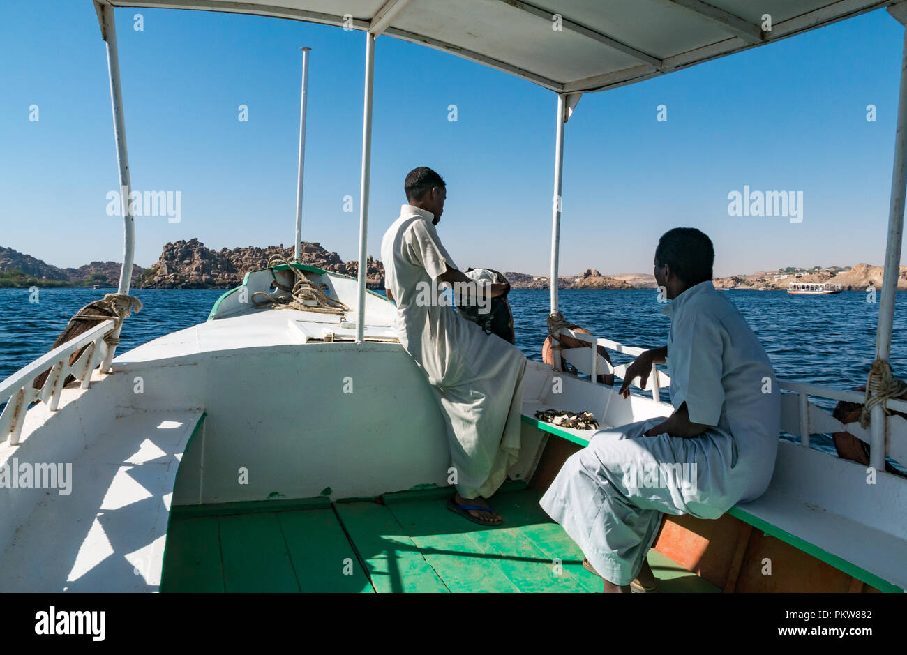 Imbarcazione turistica con locale egiziano gli uomini sul lago Nasser andando al Tempio di Philae, Agilkia Isola, Fiume Nilo, Egitto, Africa Foto Stock