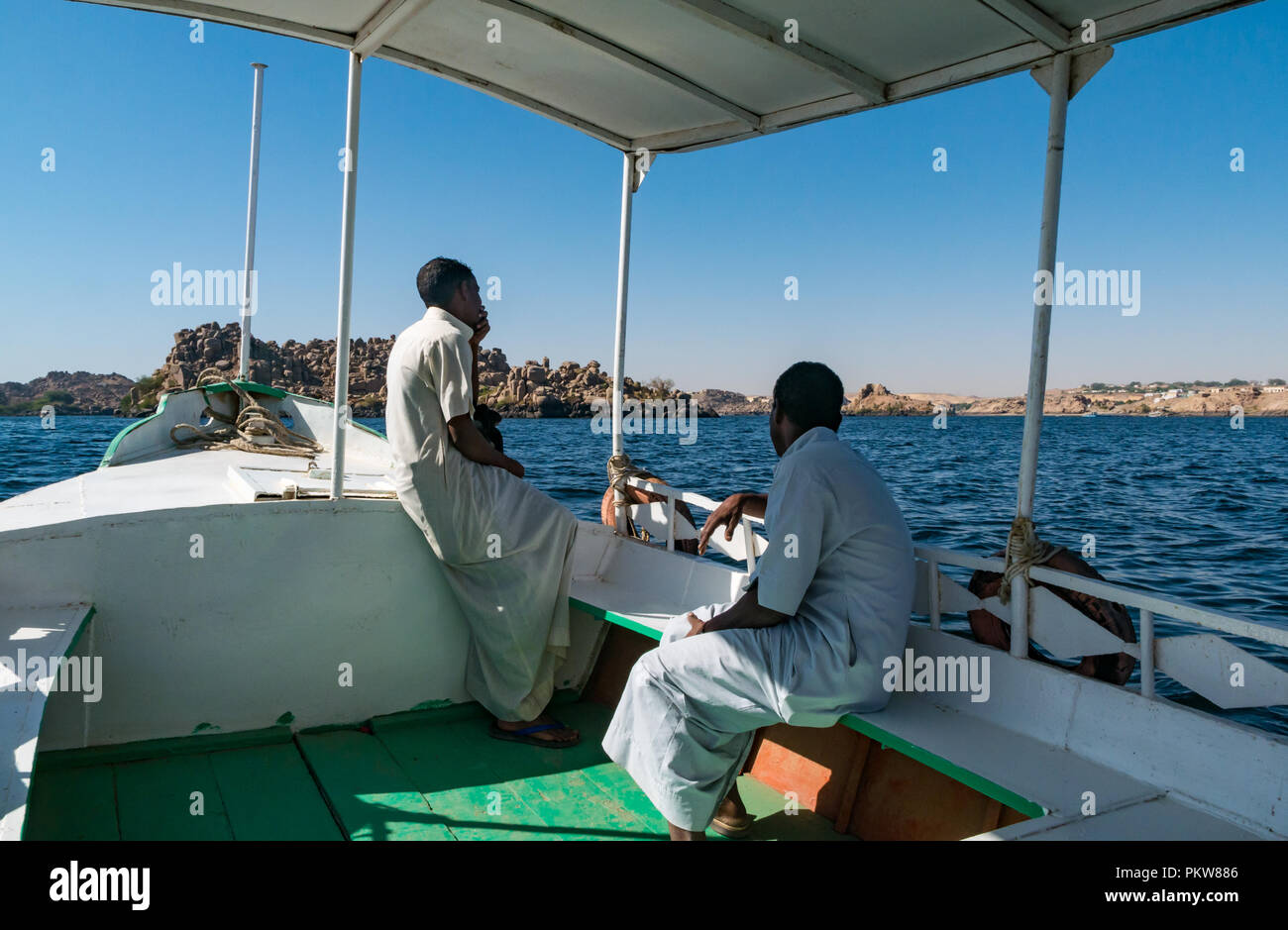 Imbarcazione turistica con locale egiziano gli uomini sul lago Nasser andando al Tempio di Philae, Agilkia Isola, Fiume Nilo, Egitto, Africa Foto Stock