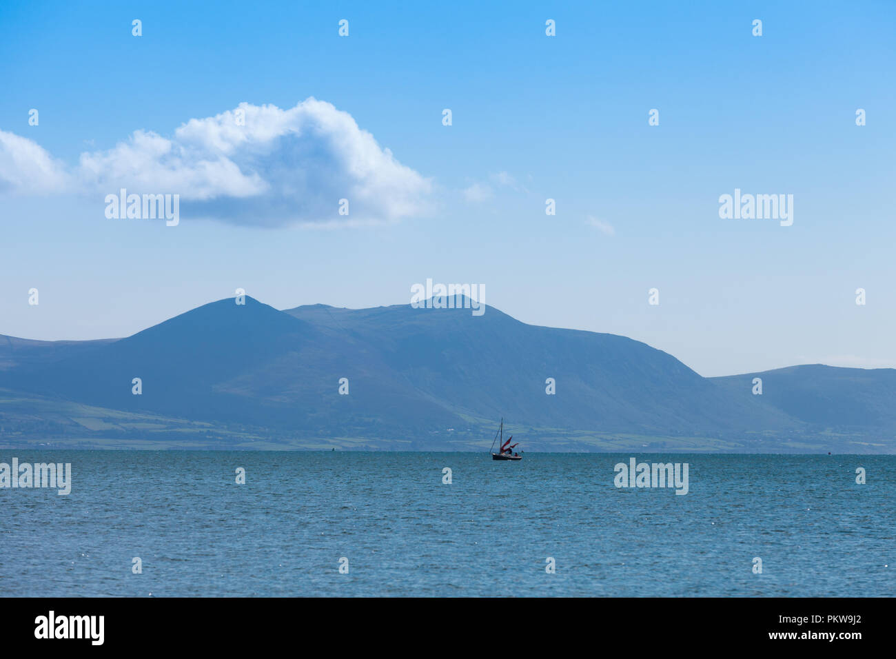 Due persone che camminano su una spiaggia tranquilla in estate, Anglesey, Galles REGNO UNITO Foto Stock