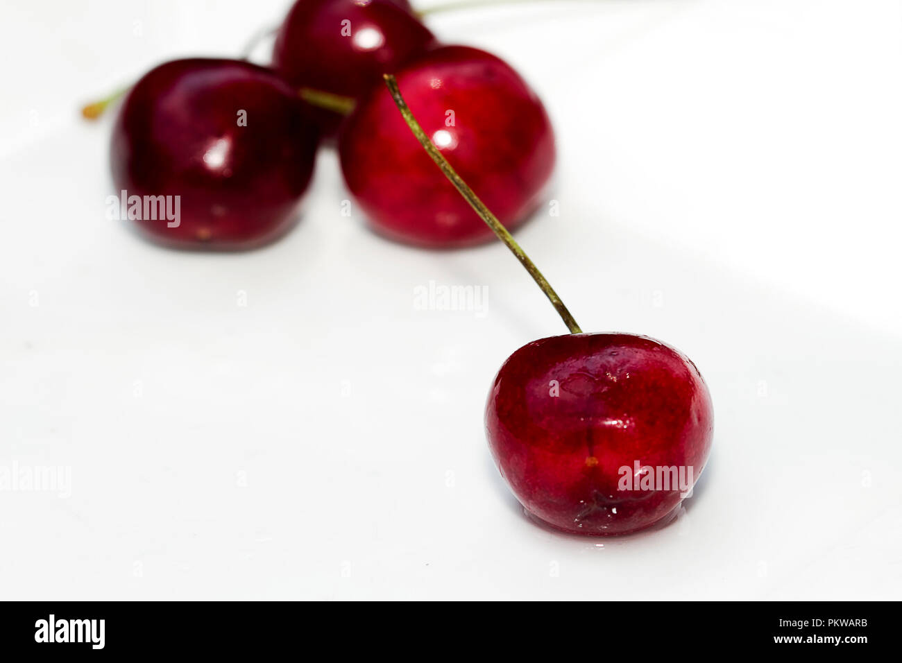 Macro immagini di ciliege rosse isolato su sfondo bianco. Foto Stock