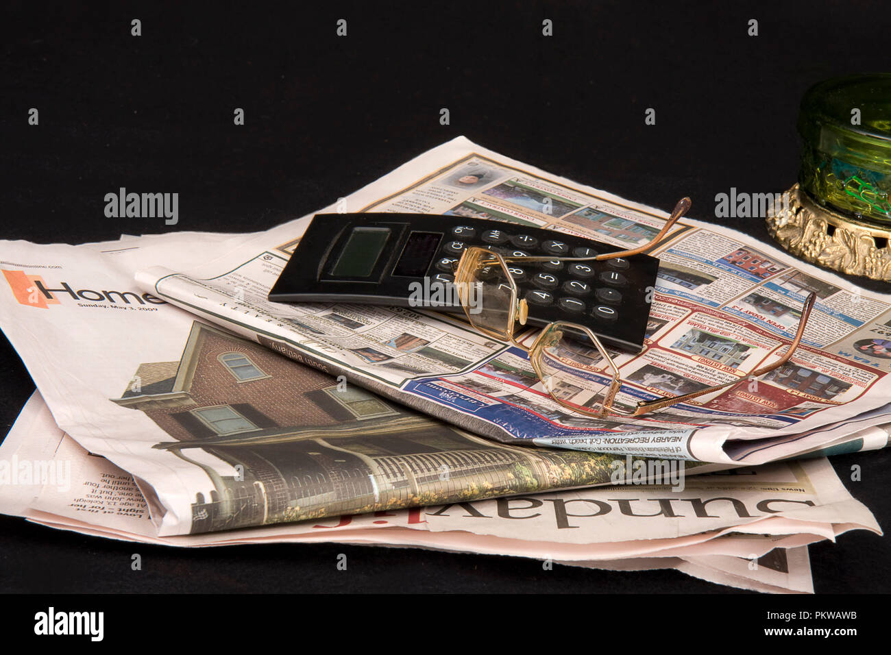 Concetto di denaro immagini con uno essendo denaro servito come pasto con monete e banconote e altri con la calcolatrice, occhiali e quotidiani. Foto Stock