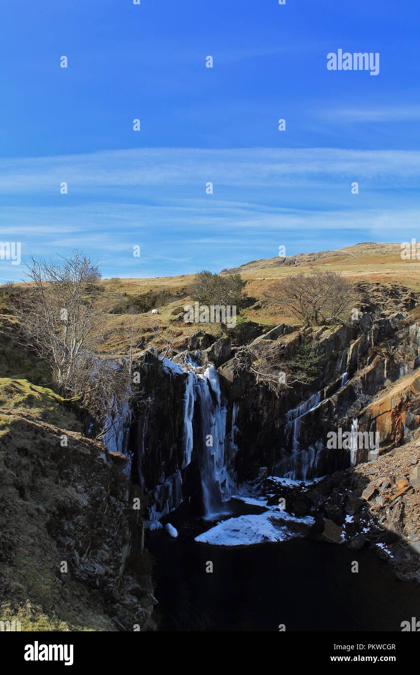 Regno Unito, Cumbria, Coniston. Vista verso la cascata ghiacciata dalla cava Banishead Torver comune nel Lake District inglese. Foto Stock