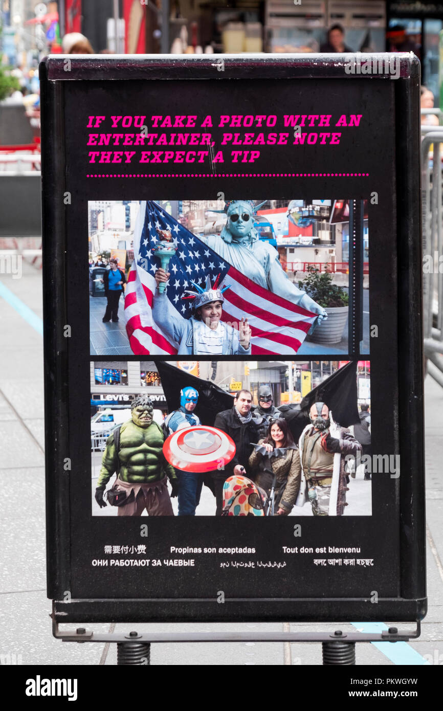 Un segno in Times Square avvertenza i turisti che gli animatori che vestito in costumi si aspettano una mancia per posa in foto. Foto Stock