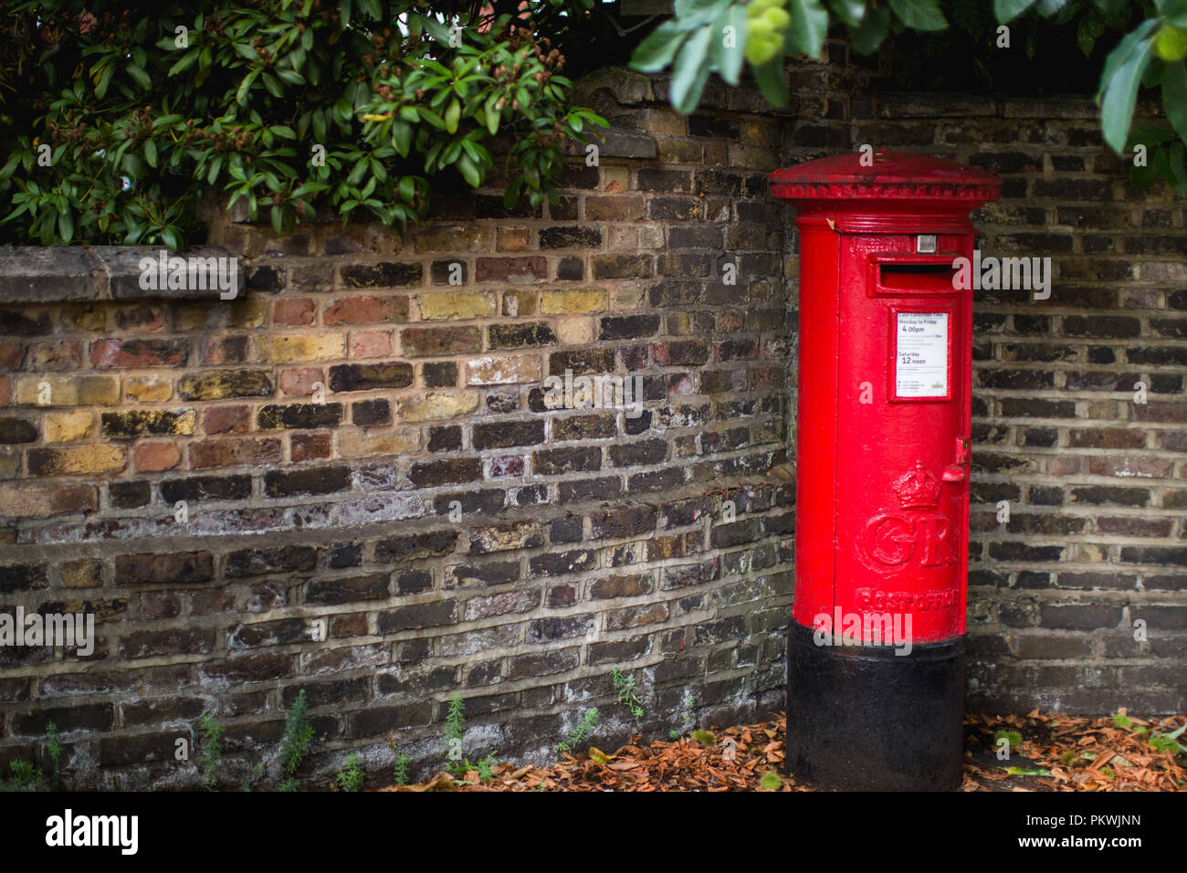 Un rosso brillante ghisa tradizionale britannica post box di proprietà di Royal Mail nel Regno Unito e ancora in uso Foto Stock