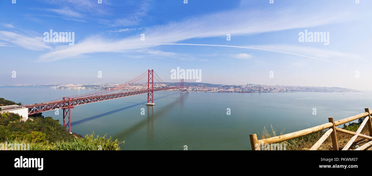 Il Ponte 25 de Abril Bridge a Lisbona, Portogallo. Collega le città di Lisbona e Almada attraversando il fiume Tago. Vista da Almada con la strategia di Lisbona attraverso t Foto Stock