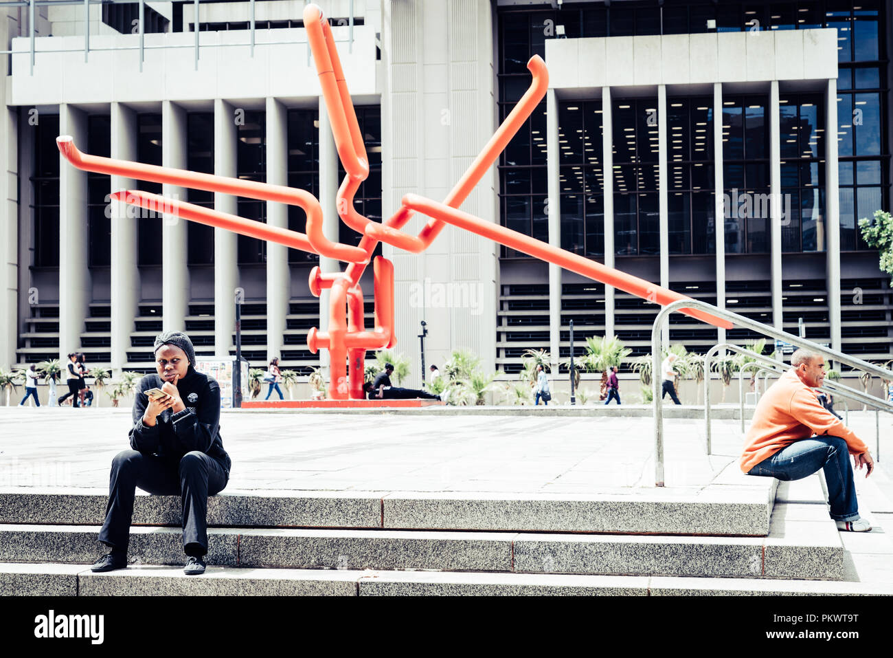 Cape Town, Sud Africa, 9 Febbraio 2018: Persone in appoggio sui gradini davanti al nodo - arte moderna scultura vicino al Centro Civico di Cape Town Foto Stock