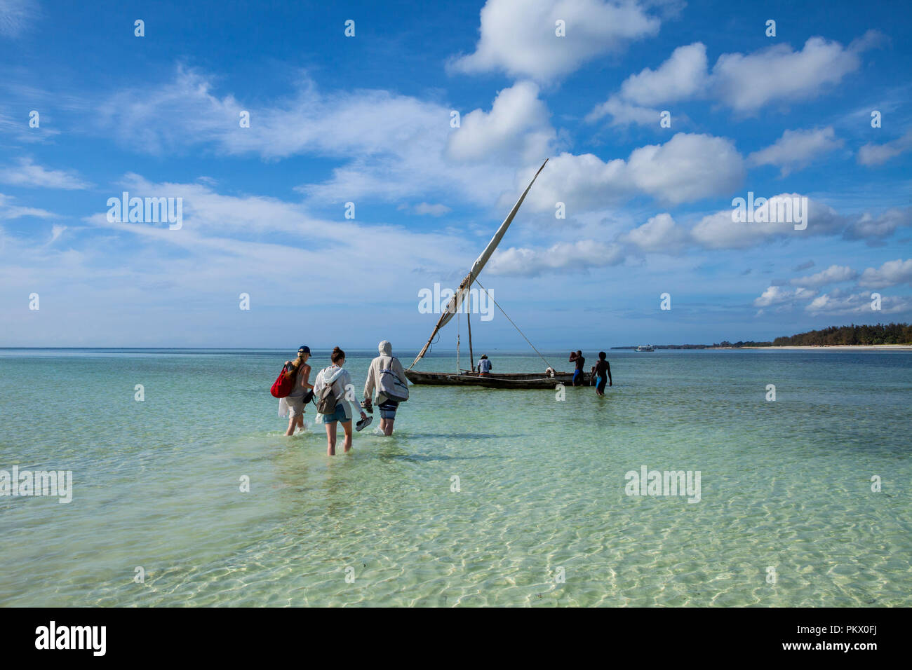 GALU KINONDO - SPIAGGIA, KENYA - Febbraio 27, 2018: Turistica preparando a nuotare in mare con i pescatori locali con una barca di legno, fatta di albero di mango. Foto Stock