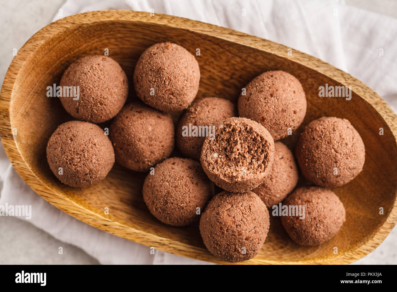 Materie vegane sfere dai dadi e cacao in una ciotola di legno, sfondo bianco. Pulire il concetto di mangiare. Foto Stock