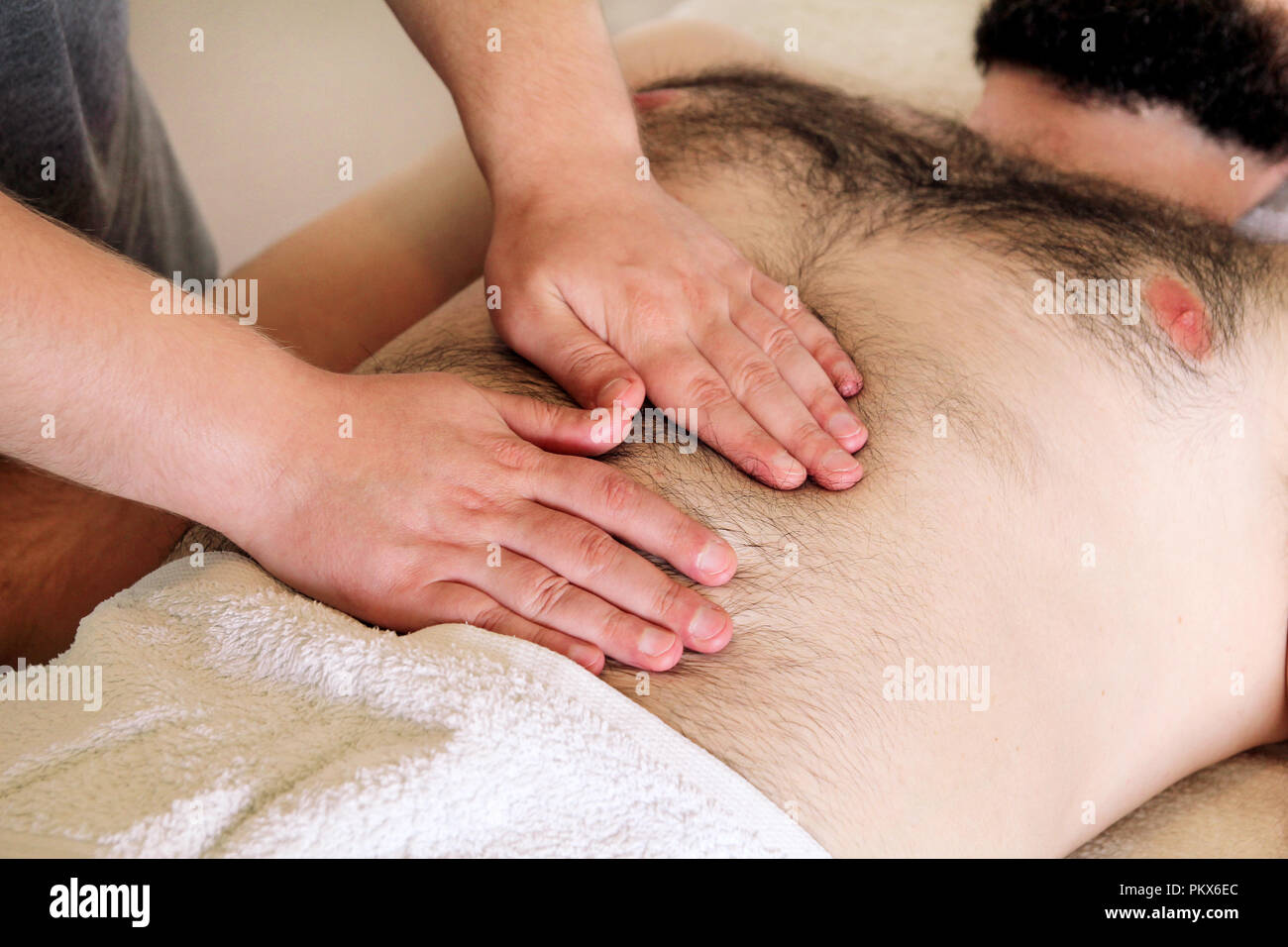 Massaggio pancia in studio per massaggi. Uomo di ottenere un massaggio  dello stomaco. Stretta di mano maschio massaggio addominale. Massaggiatore  Massaggio pancia ragazzi Foto stock - Alamy