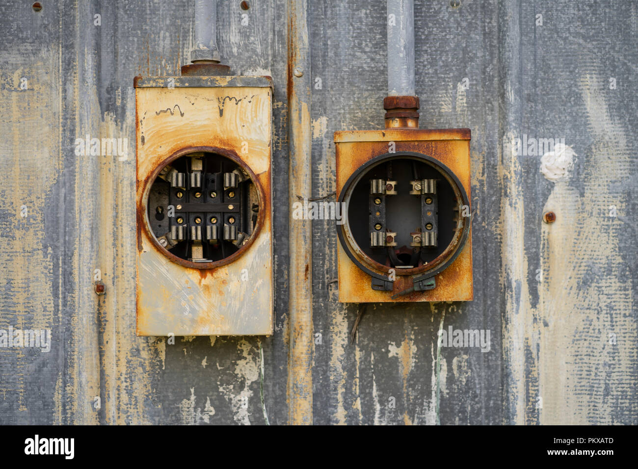 Due vecchie scatole elettriche sedere vuoto dei fusibili e non utilizzati al di fuori di ruggine negli elementi Foto Stock