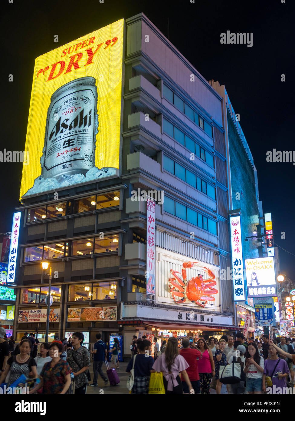 Una vista del trafficato quartiere Dotonbori di notte, con il granchio gigante segno di Kani Doraku ristorante e la Asahi Super Dry segno al neon. Osaka, Giappone. Foto Stock