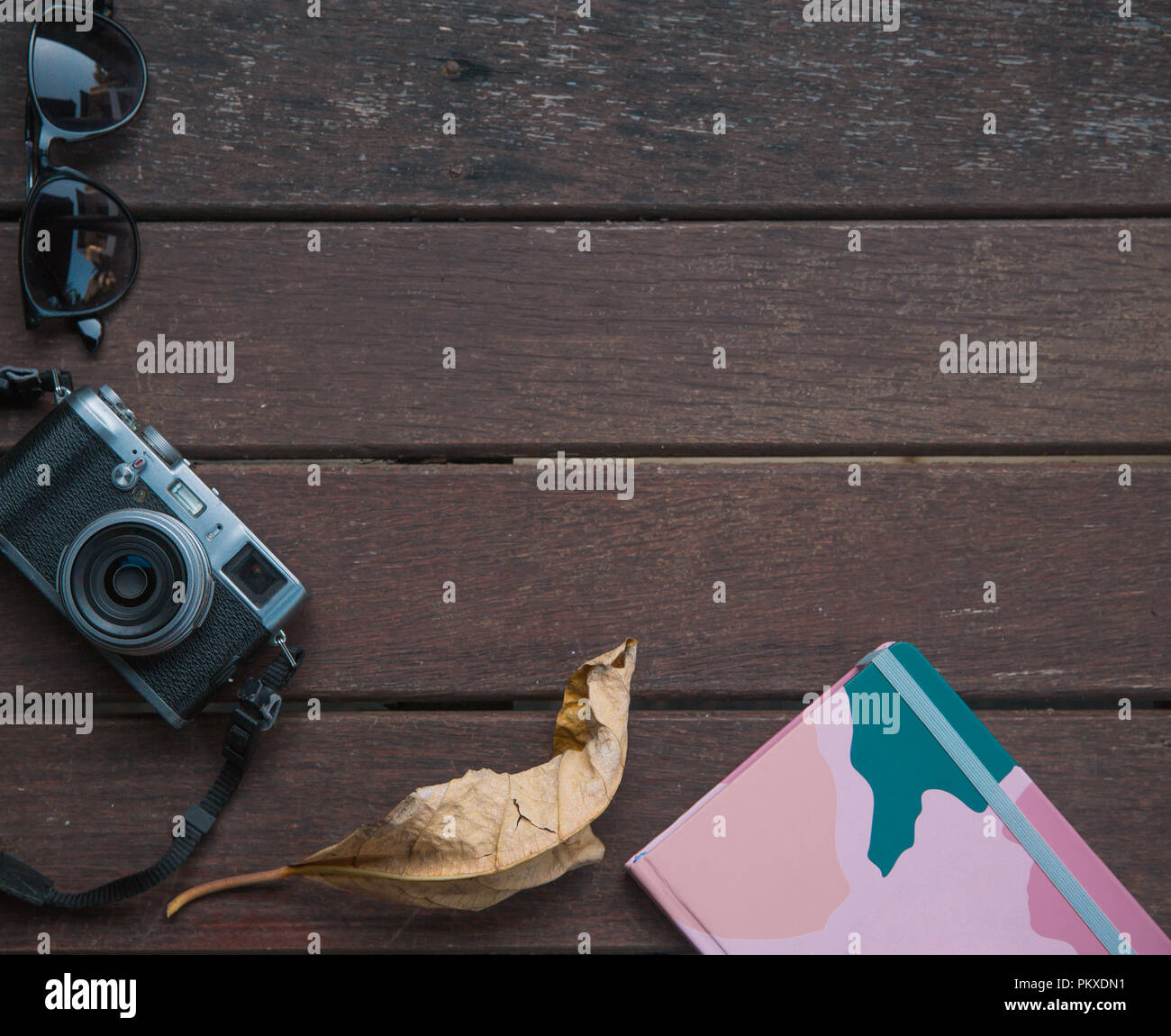 Autunno sfondo su un tavolo di legno con una vecchia macchina fotografica, foglie di autunno e il blocco note. Flay laici Foto Stock