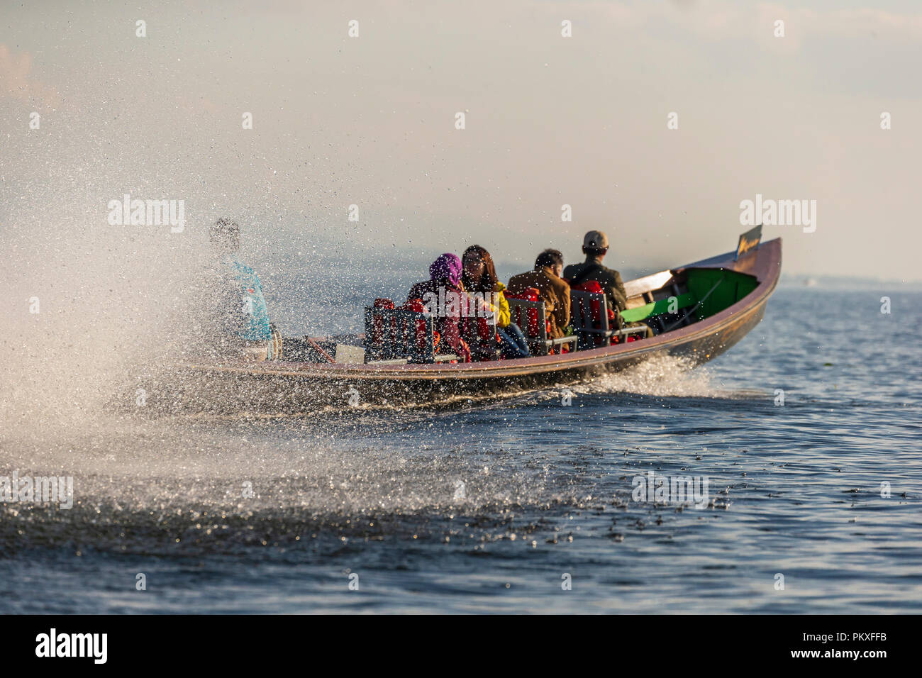 Long Tail canoe pieno di turisti whizzing veloce sul Lago Inle, Myanmar Foto Stock