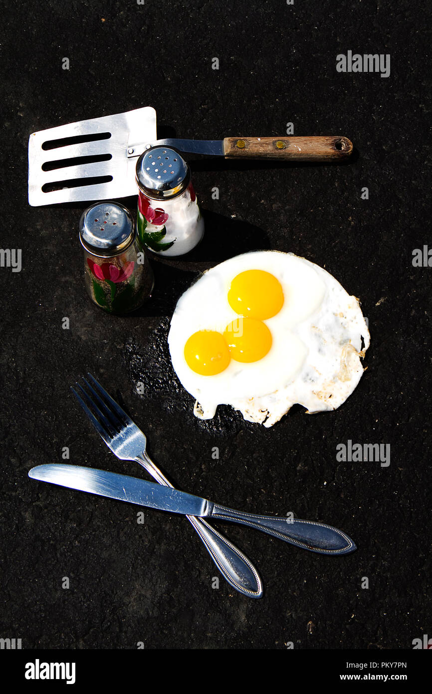 Uova in cartone con alcune rotte. Alcune immagini di uova la frittura su asfalto caldo, concetto. Foto Stock