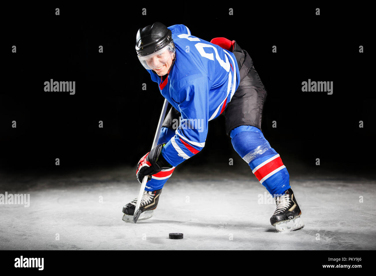 Giovane giocatore di hockey il pattinaggio su ghiaccio in attacco Foto Stock