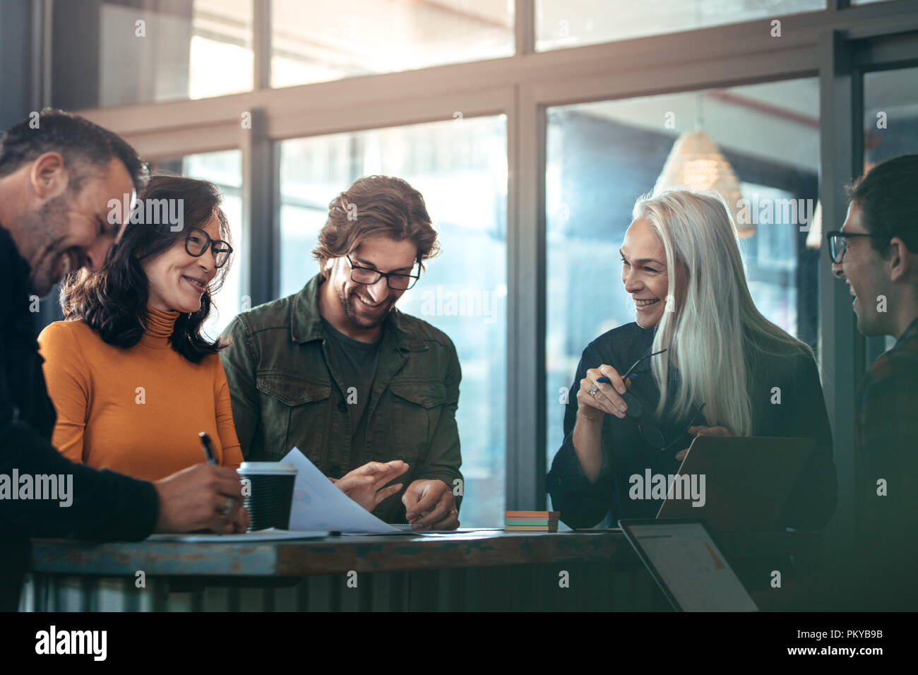 Un gruppo di persone di affari riunione in ufficio. Ufficio permanente dei lavoratori attorno ad un tavolo e sorridente durante la riunione di affari. Foto Stock