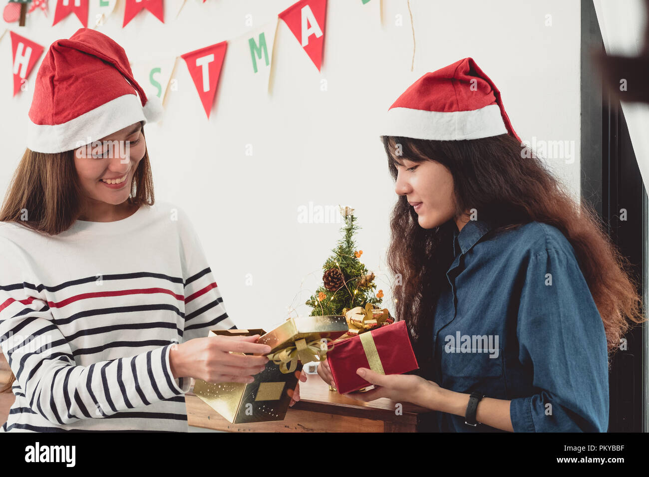 Due asia donna sorpresa quando apri gold confezione regalo a festa con decoro bandiera a sfondo,Natale dando parte presente,wow sentimento e hap Foto Stock