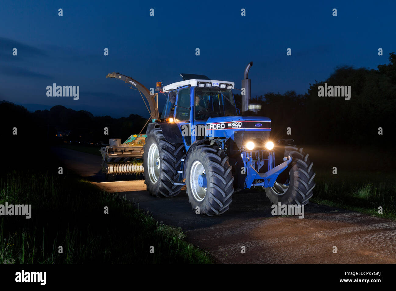 1990 Ford 8830 power shift + Reco Mengele SH40N trincia voce torna alla fattoria dopo una lunga giornata di raccolta di insilato per bestiame da latte Foto Stock