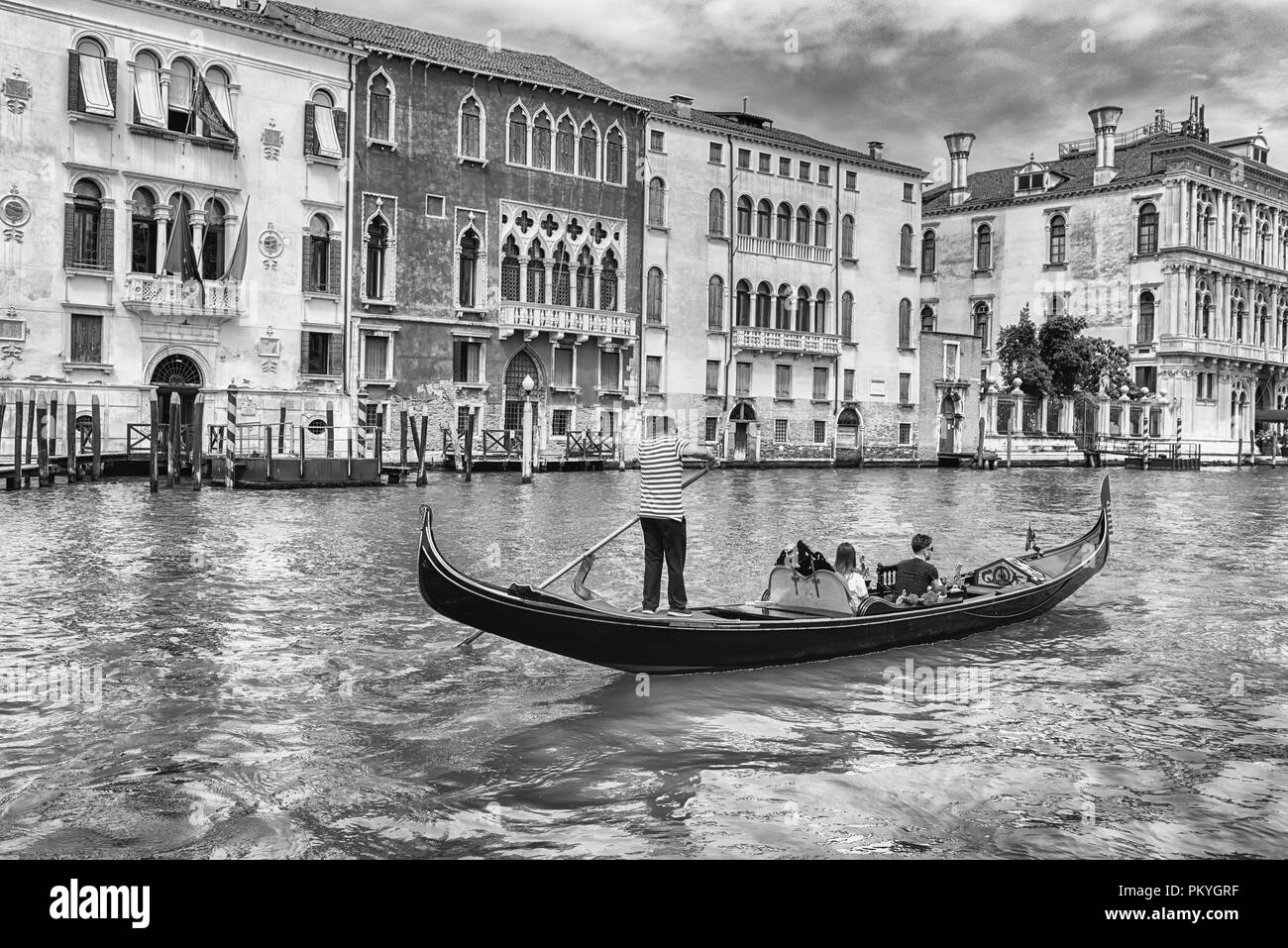 Persone non identificate su un tradizionale Gondola con architettura paesaggistica lungo il Canal Grande nel sestiere di Cannaregio a Venezia, Italia Foto Stock