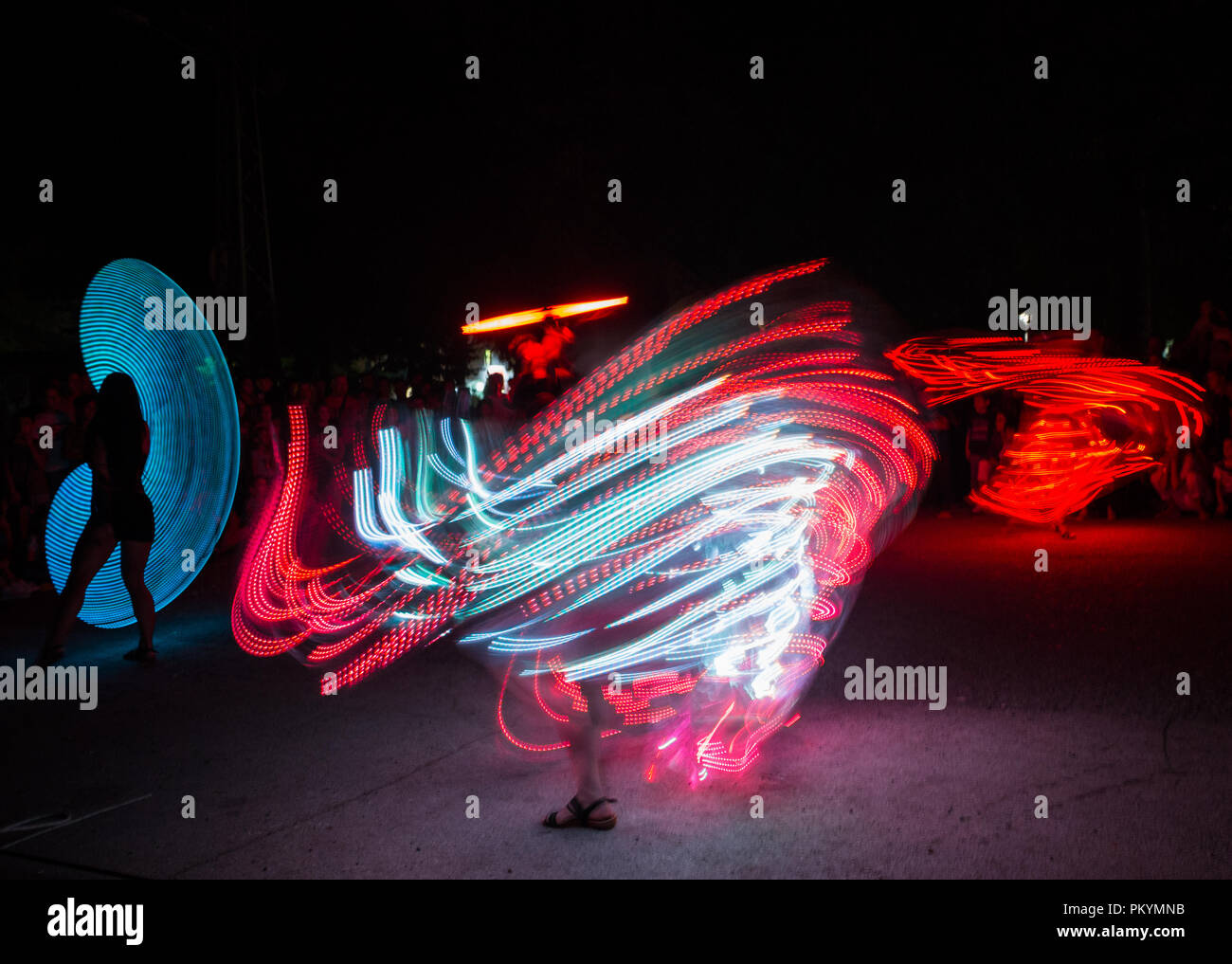 Una lunga esposizione foto con ragazze danza vestito di luce a led costumi. Foto Stock