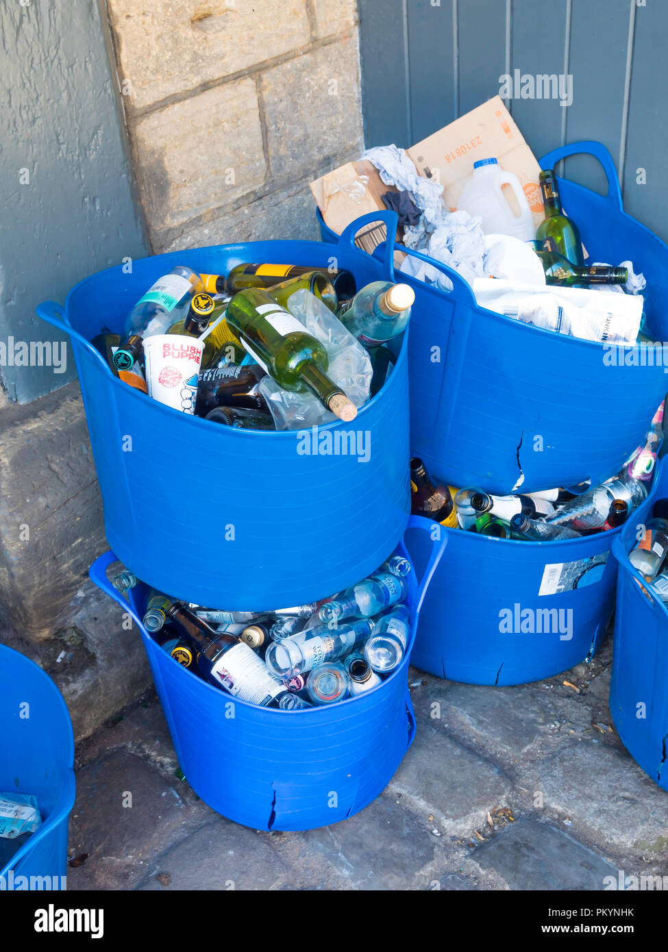 Il riciclaggio dei contenitori blu per la birra e le bottiglie di vino e al di fuori di una public house Foto Stock