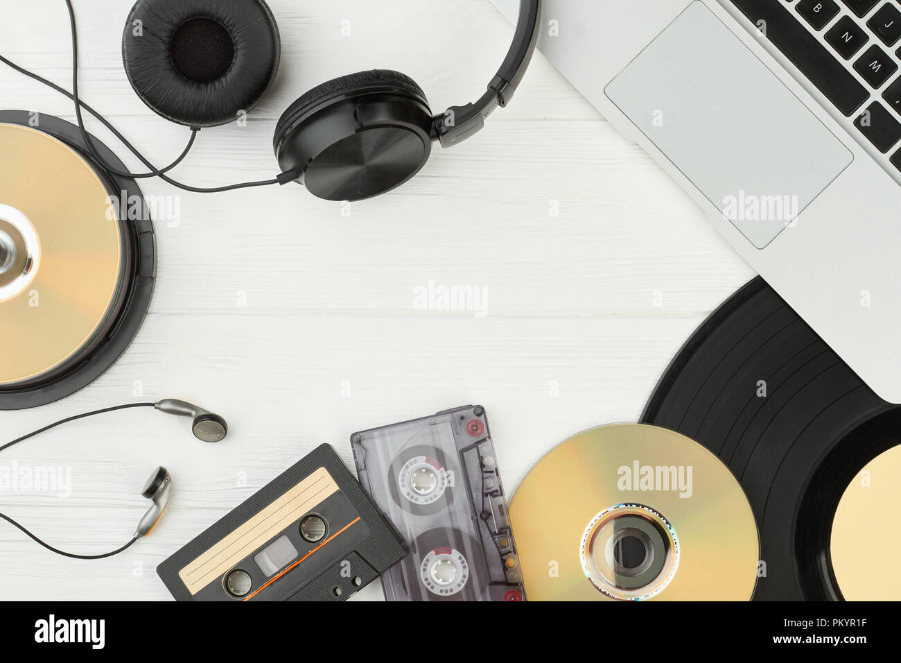 Tabella con audio musica tecnologie. Il telaio dal laptop, vinile, auricolari, compact disc e audio cassette con copia spazio. E obsoleti Foto Stock