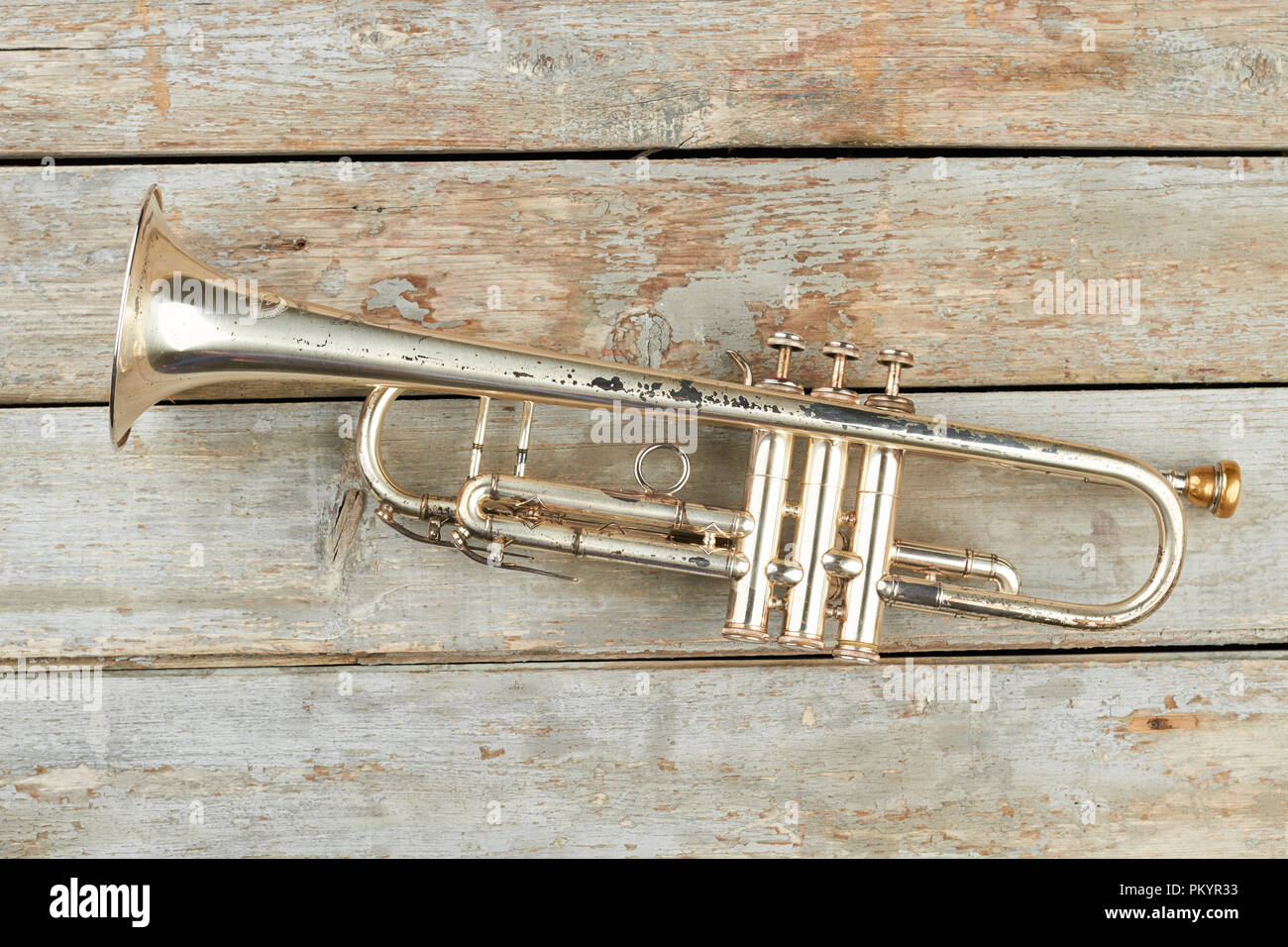 Rusty tromba in legno rustico sfondo. Ancora vita vecchia tromba. Fanfara strumento musicale. Foto Stock