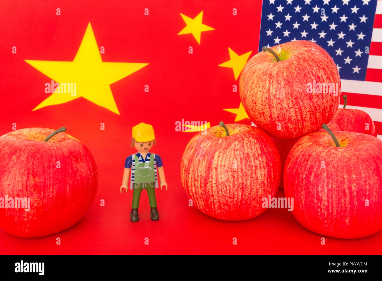 U.S red apple le esportazioni con bandiera cinese e piccolo giocattolo agricoltore - metafora noi apple Industria, commercio cinese tariffe doganali sulle importazioni di mele per gli Stati Uniti. Foto Stock