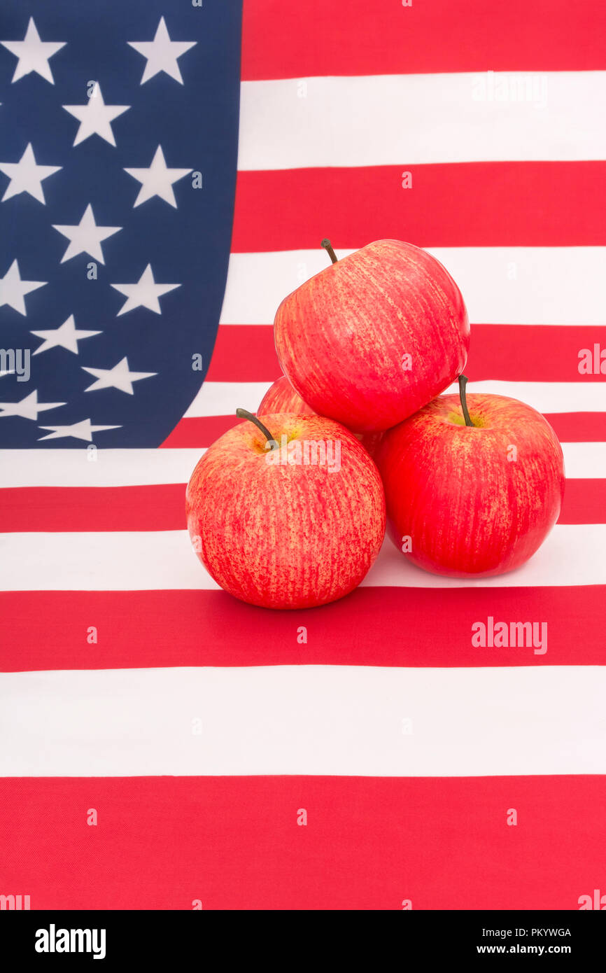 Le mele rosse con U.S. Bandiera americana / a stelle e strisce - metafora noi industria Apple, Apple il giorno e commercio cinese tariffe doganali sulle importazioni di mele NEGLI STATI UNITI. Foto Stock