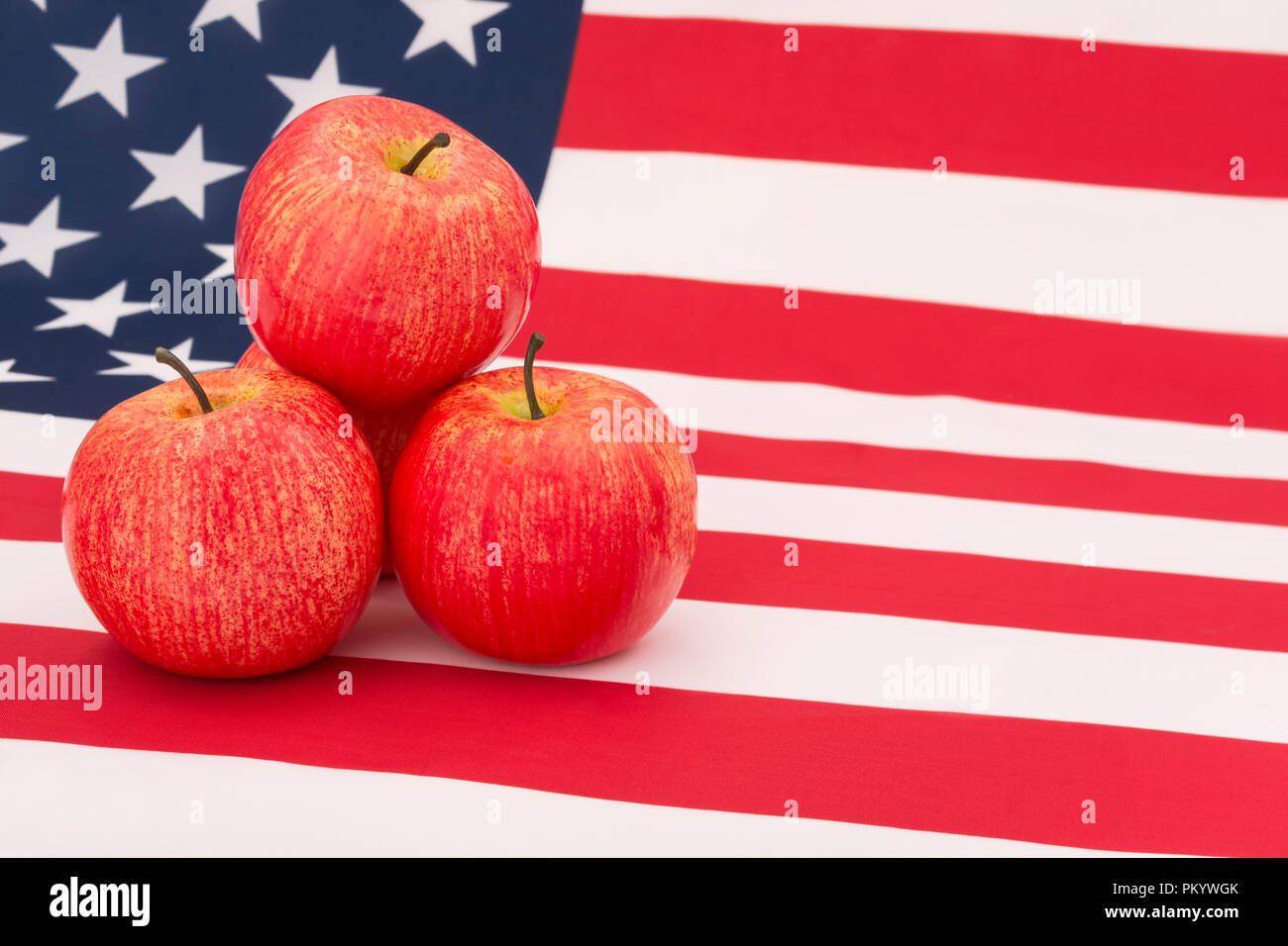 Mele rosse con bandiera americana / Stars & Stripes. Esportazioni alimentari STATUNITENSI, industria della mela statunitense, Apple Day, tariffe cinesi sulle importazioni di mele statunitensi. Foto Stock