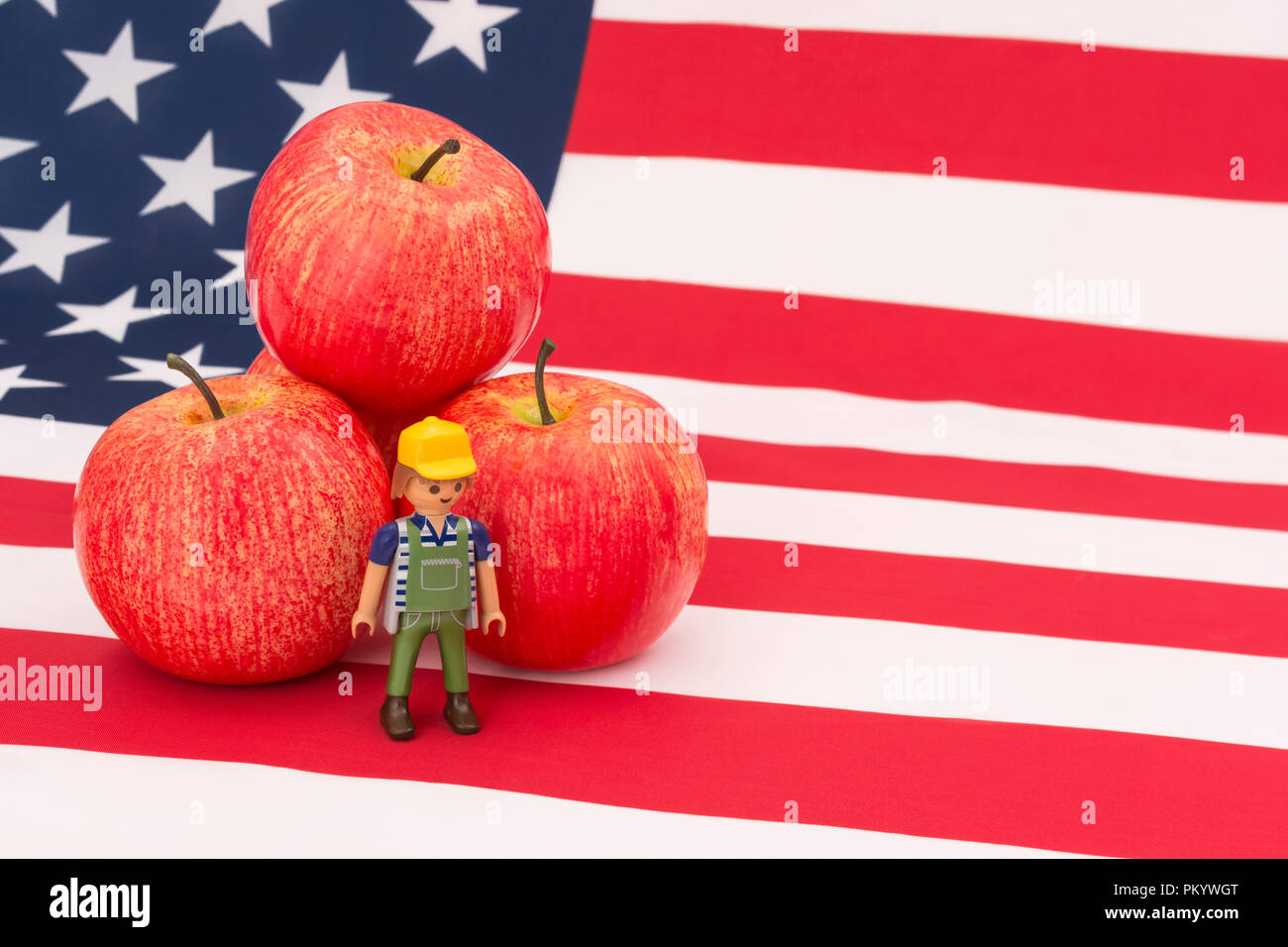 Mele rosse + bandiera americana USA / Stelle e Strisce. Le esportazioni alimentari statunitensi, l’industria delle mele americana, le tariffe commerciali cinesi sulle mele americane importate. Foto Stock